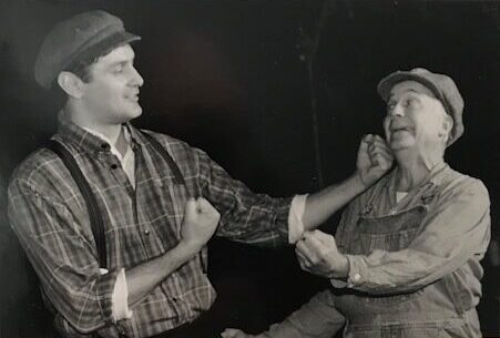 Two men in 1930's constume boxing.
